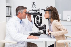 Woman doing eye test with optometrist in medical office
