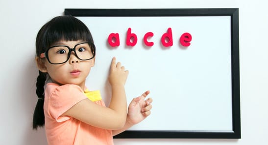 Child wearing glasses at whiteboard