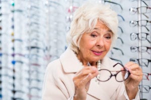 Senior woman trying on eyeglasses